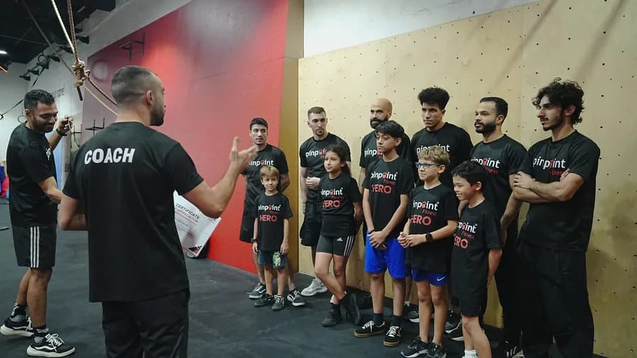 A coach guiding a student through a vault